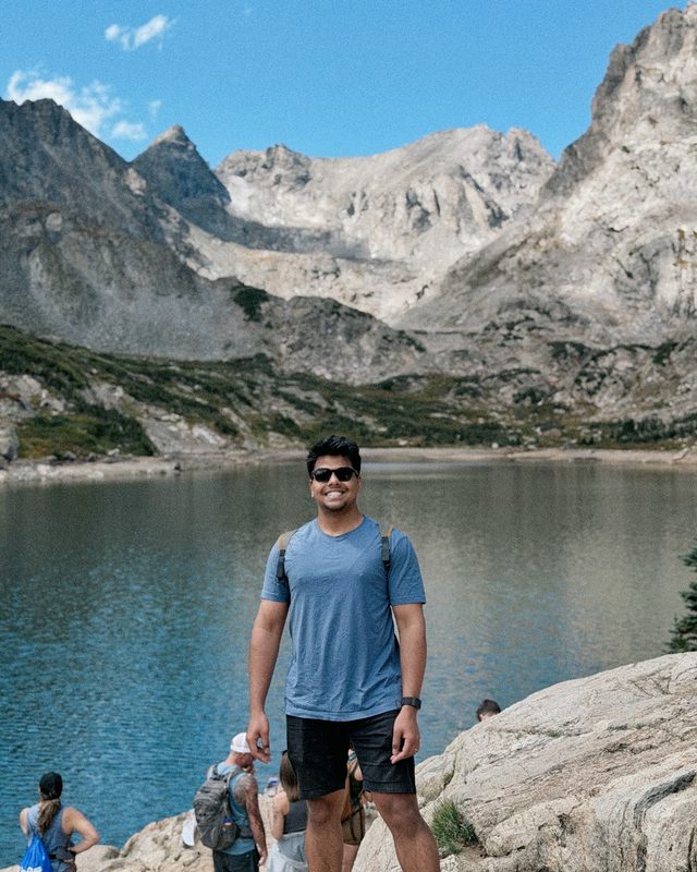 Ashwin at an alpine lake below granite peaks